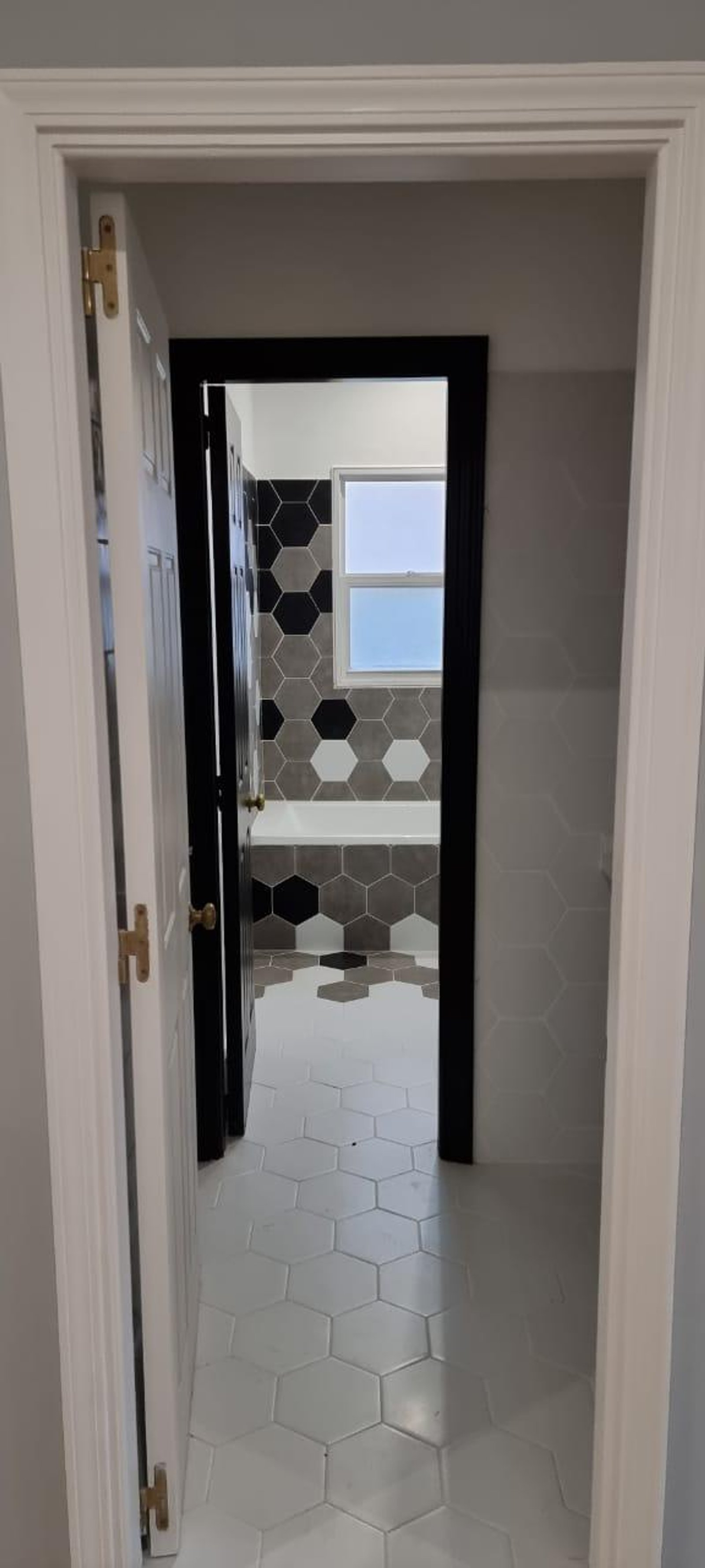 Banheiro moderno com banheira freestanding e azulejos hexagonais — projeto La Lomada, por Arcucci Arquitectura, em H5CM+WM